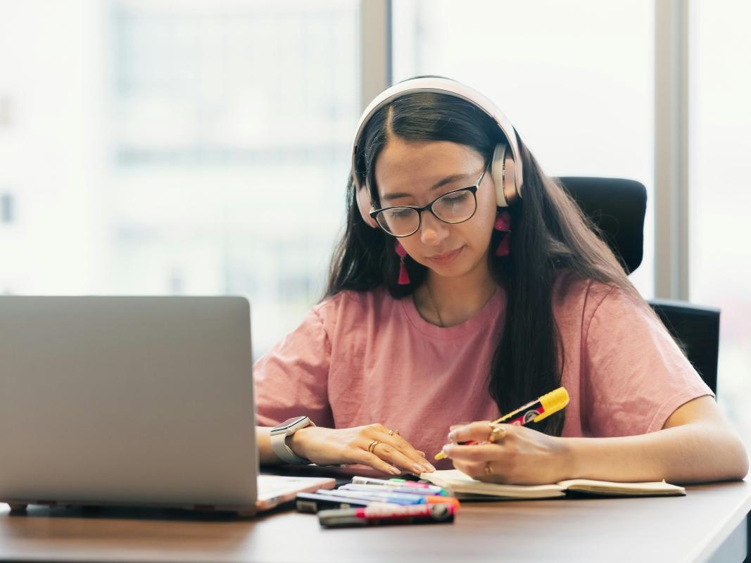 A female student with a computer working on an assignment.